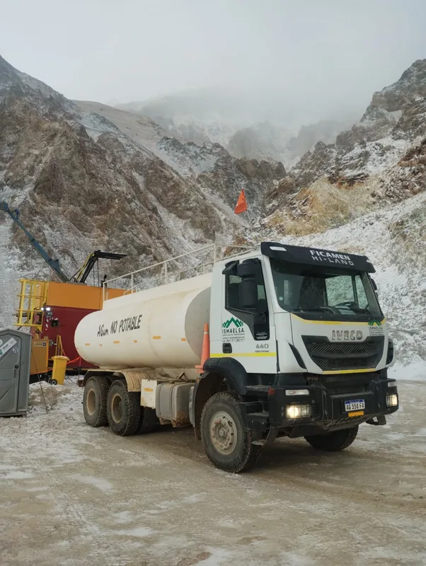 Camión aguatero de ISMAEL S.A. con tanque de agua no potable en un frente minero nevado de la cordillera de San Juan