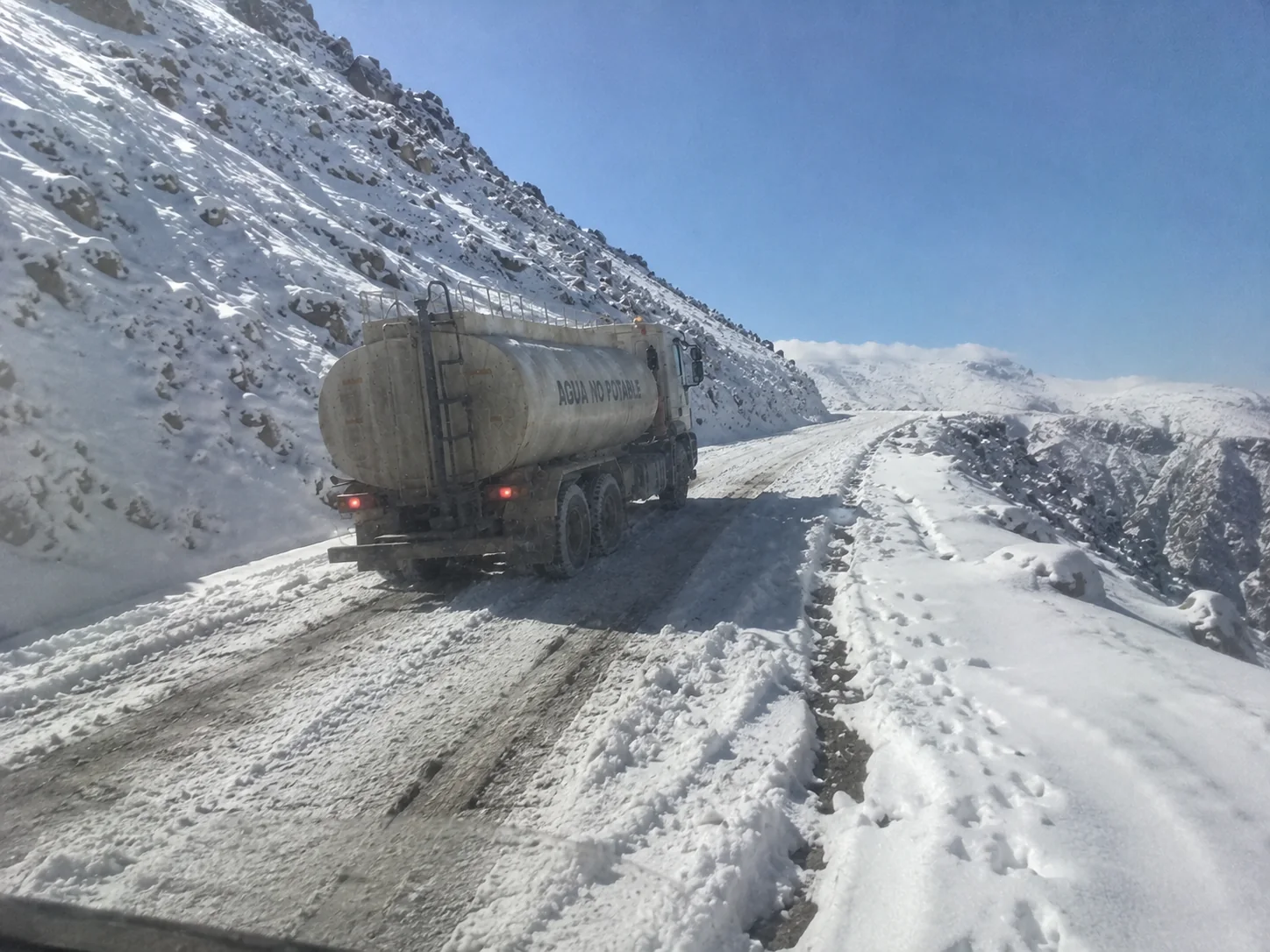 Aguatero de ISMAEL S.A. en un camino de cornisa nevado con cielo despejado en San Juan