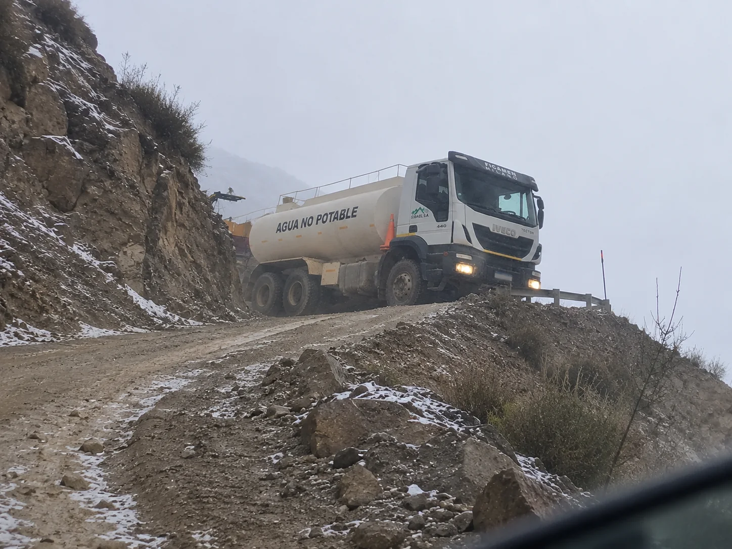 Aguatero de ISMAEL S.A. en un camino de cornisa con nieve en la cordillera de San Juan
