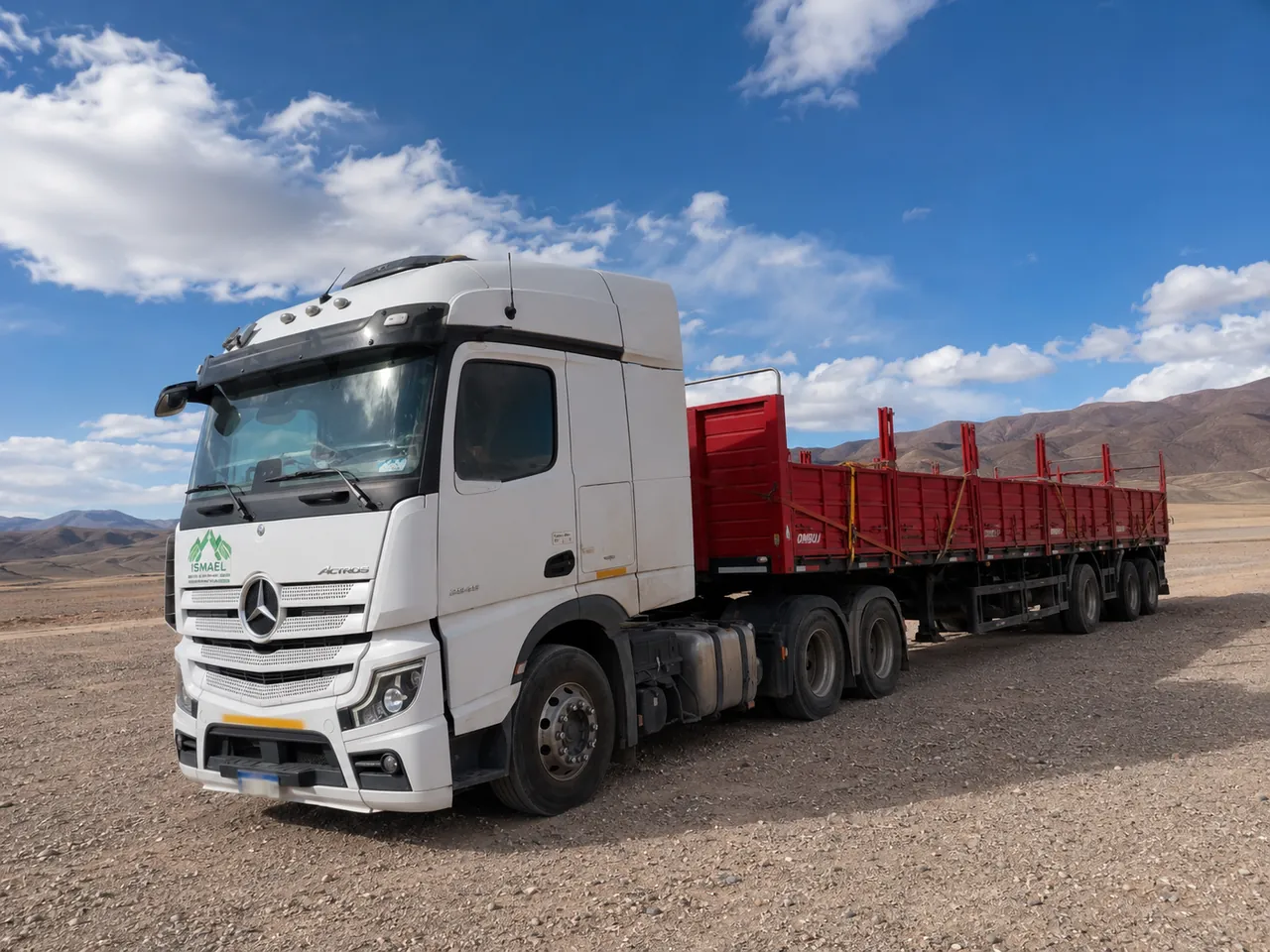 Tractor Mercedes-Benz de ISMAEL S.A. con semirremolque de barandas cargado de materiales en una ruta de la cordillera de San Juan